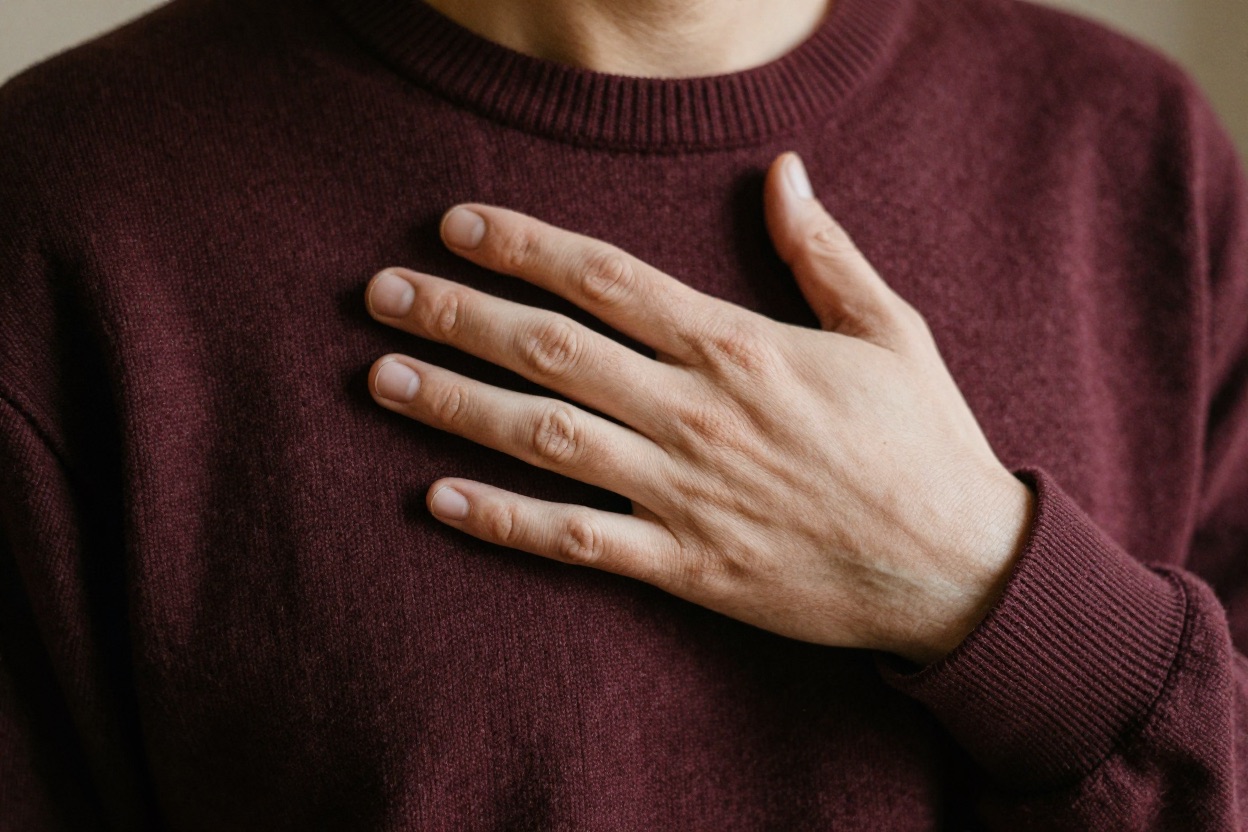 A hand resting over the heart