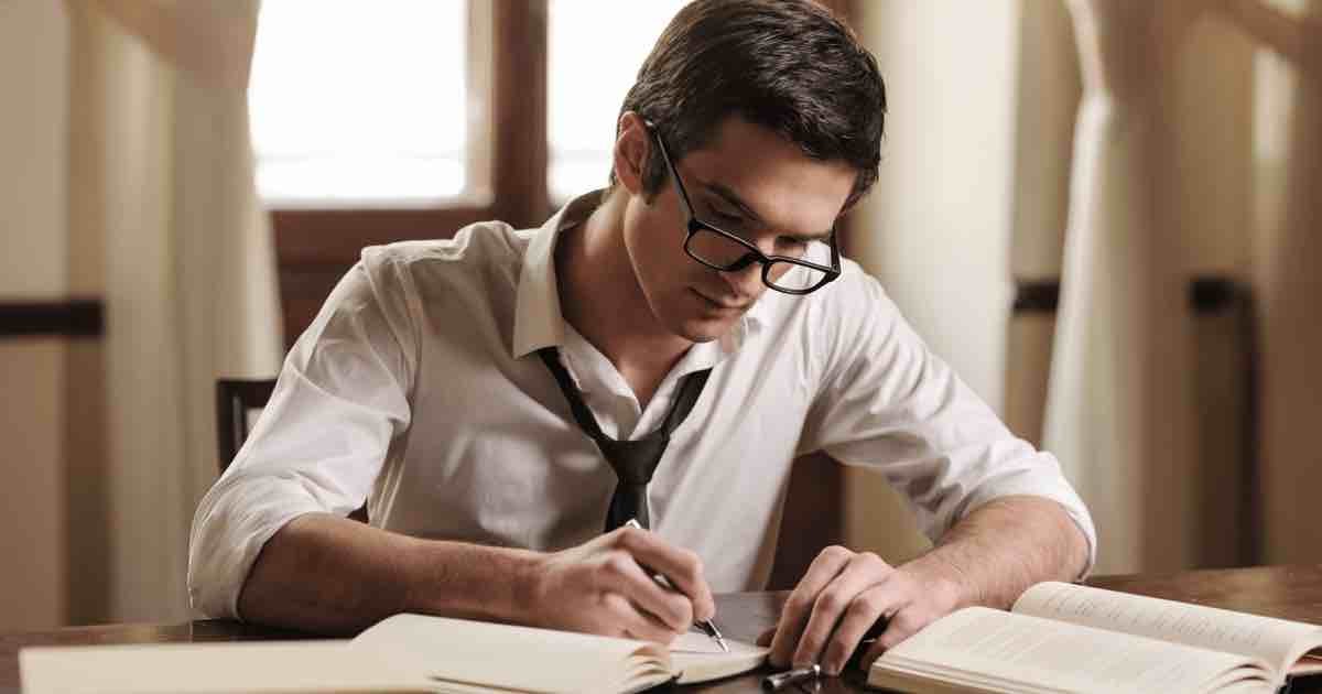 man studying with pen and paper